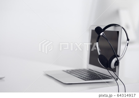 Call center and communication support, customer service help desk. VOIP headset on laptop computer Call center and communication support, customer service help desk. VOIP headset on laptop computer 64314917