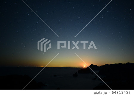 月齢11の月入りに照らされる岬と沈む春の星座。 64315452