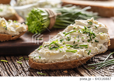 Slices of crusty bread with a cream cheese spread 64316887