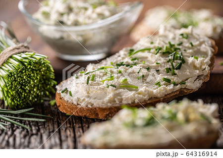 Chive cream cheese spread on a bread slice next to Chive cream cheese spread on a bread slice next to 64316914