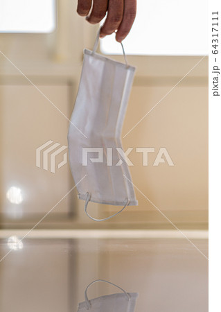 a medical mask hangs on the arm above the floor. fatigue of doctors and medical staff. fighting the covid-19 coronavirus pandemic. a worldwide problem and the tragedy a medical mask hangs on the arm above the floor. fatigue of doctors and medical staff. fighting the covid-19 coronavirus pandemic. a worldwide problem and the tragedy 64317111
