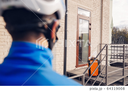 Contacless delivery service during quarantine. Man delivers food and shopping bags during isolation Contacless delivery service during quarantine. Man delivers food and shopping bags during isolation 64319008