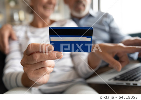 Close up mature couple paying online by plastic credit card 64319058