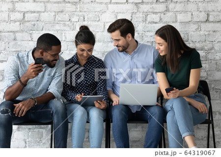 Smiling diverse candidates prepare for interview using gadgets Smiling diverse candidates prepare for interview using gadgets 64319067