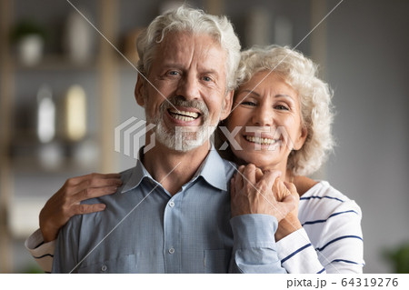 Head shot portrait smiling older man and woman hugging 64319276