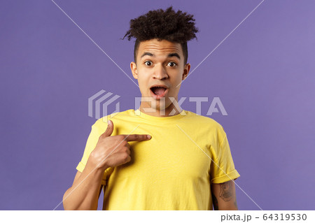 Who me, no way. Portrait of surprised, happy rejoicing young man looking with disbelies as being chosen from all candidates, pointing at himself open mouth fascinated, purple background Who me, no way. Portrait of surprised, happy rejoicing young man looking with disbelies as being chosen from all candidates, pointing at himself open mouth fascinated, purple background 64319530
