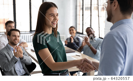 Male boss handshake female employee greeting with success at meeting 64320557