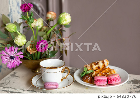 Breakfast with a Cup of tea, honey waffles and macaroons Breakfast with a Cup of tea, honey waffles and macaroons 64320776