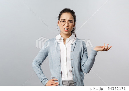So what. Skeptical arrogant asian woman, looking with dismay and judgement camera, raise hand sideways and shrugging unbothered, look frustrated at something awful and bad, grey background So what. Skeptical arrogant asian woman, looking with dismay and judgement camera, raise hand sideways and shrugging unbothered, look frustrated at something awful and bad, grey background 64322171
