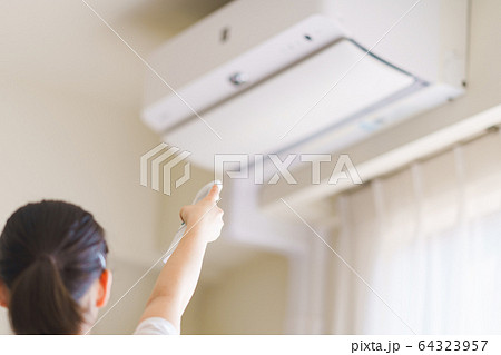 エアコン　温度調節　換気　冷房　夏　リモコン　リビング　人物　女性　日本人　ウィルス対策　空気清浄機 64323957