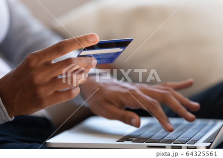 Close up of girl hold bank card and type on laptop 64325561