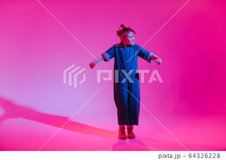 Young stylish girl dancing in the Studio on a colored neon background. Music dj poster design. 64326228