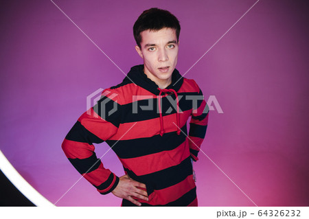 Young Man in a Jumper Dancing Contemporary Dance in Studio. Breakdancing. Dance School Poster. Copy Space. Battle competition announcement. Pink and Blue Background. 64326232
