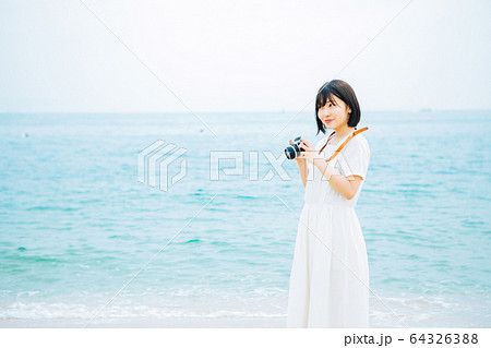 海で写真を撮る女性 海で写真を撮る女性 64326388