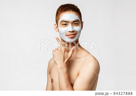 Beauty, skincare and hygiene concept. Portrait of happy, pleased young asian man feeling beautiful, vibing at bathroom with facial cream, smiling like his face appearance, stand white background Beauty, skincare and hygiene concept. Portrait of happy, pleased young asian man feeling beautiful, vibing at bathroom with facial cream, smiling like his face appearance, stand white background 64327888