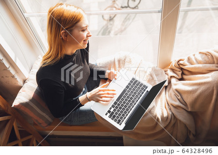 Young woman using gadgets to watch cinema, photos, online courses, taking selfie or vlog, online shopping Young woman using gadgets to watch cinema, photos, online courses, taking selfie or vlog, online shopping 64328496