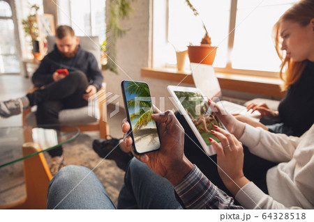 Young friends using gadgets to watch cinema, photos, online courses, taking selfie or vlog 64328518
