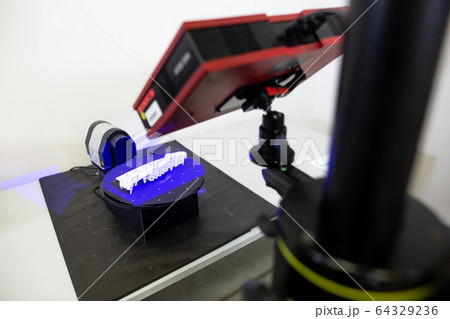 Professional 3D scanner scanning an industrial object, plastic molding placed on a turntable, metrology concept Professional 3D scanner scanning an industrial object, plastic molding placed on a turntable, metrology concept 64329236
