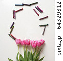 Pink tulips with colored children's pencils. Top view of a spring bouquet on a white background. 64329312