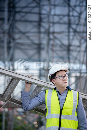 Maintenance worker man carrying aluminium ladder 64329422