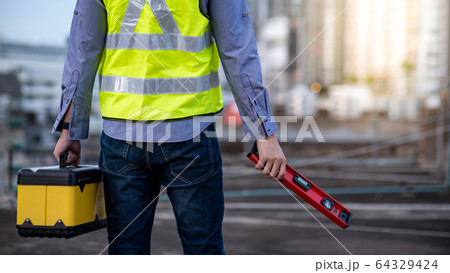 Worker man holding spirit level tool and box 64329424
