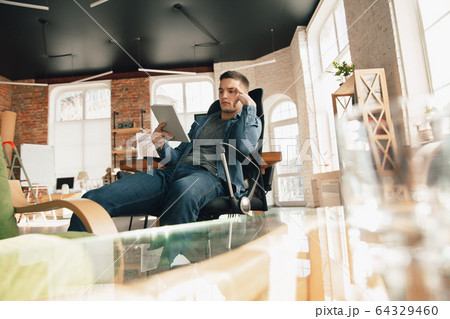 Creative workplace - organized work space as you like for inspiration, man working in office in relaxed posture Creative workplace - organized work space as you like for inspiration, man working in office in relaxed posture 64329460