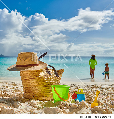 Toddler boy on beach with mother. Beach bag and Toddler boy on beach with mother. Beach bag and 64330974