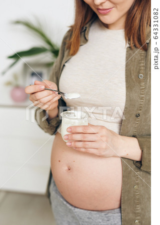 Eating natural yogurt with spoon Eating natural yogurt with spoon 64331082