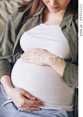 Pregnant woman embracing belly Pregnant woman embracing belly 64331121