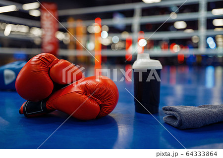 Boxing gloves and sport equipment on ring, nobody 64333864