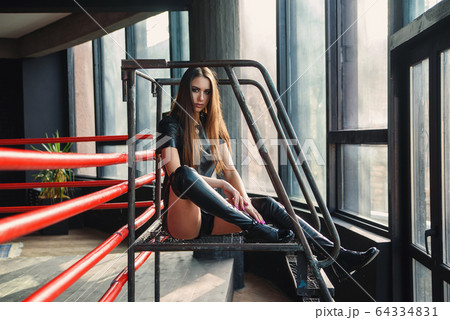 Attractive model wearing leather shorts and jacket posing on boxing ring. Attractive model wearing leather shorts and jacket posing on boxing ring. 64334831