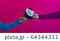 Women hands and arms exchanging happy birthday card with saturated pink background 64344311