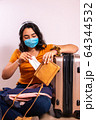 Anxious travelling girl waiting in quarantine in the airport, pulling out a tissue 64344532