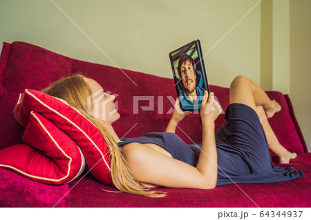 Man and woman are talking through a video call on a tablet 64344937