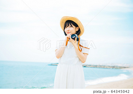 海辺で写真を撮る女性 海辺で写真を撮る女性 64345042