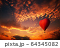 Red hot air balloon in the shape of a heart, Colorful hot-air balloon flying over sunset 64345082