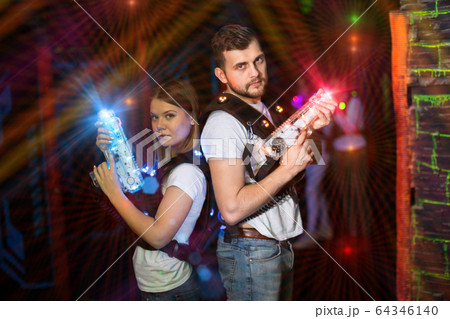 Couple standing back to back in laser beams Couple standing back to back in laser beams 64346140