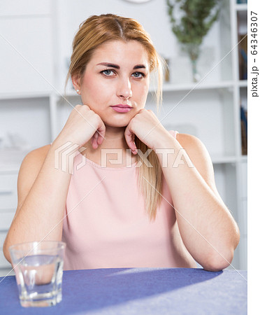 Young female is thoughtful and bored sitting alone 64346307