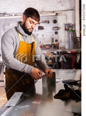 Young man engineer calculation size of material Young man engineer calculation size of material 64347096