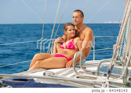 Woman and man on yacht deck 64348143
