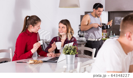 Two girls at kitchen of hostel 64348227