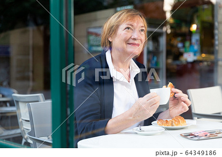 Elderly woman drinking coffee in cafe Elderly woman drinking coffee in cafe 64349186