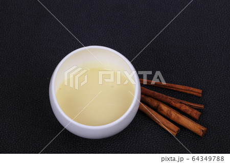 Condenced milk in the bowl with sinnamon and 64349788