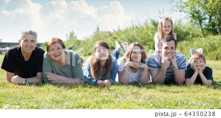 People of different ages taking photos on the lawn People of different ages taking photos on the lawn 64350238