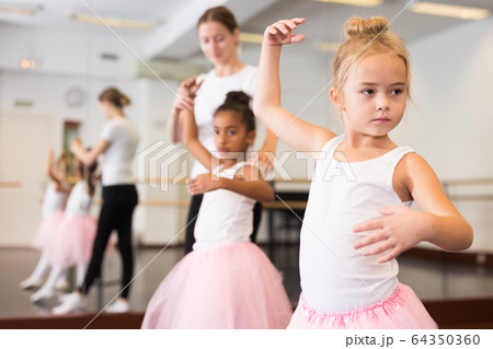 Ballet teacher and two little girls 64350360