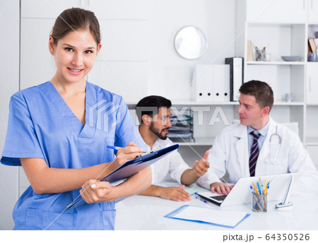 Female doctor writing notes on clipboard 64350526
