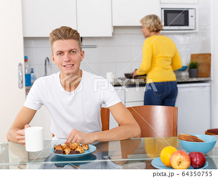 Senior woman taking care of her adult son Senior woman taking care of her adult son 64350755