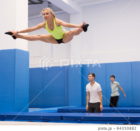 Woman jumping in trampoline center Woman jumping in trampoline center 64350882