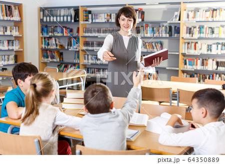 Female teacher working with pupils Female teacher working with pupils 64350889