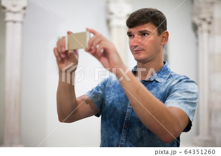 Man taking photo of exposition 64351260